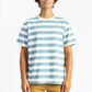 a man wearing a light blue/white tee shirt with big stripes and yellow shorts