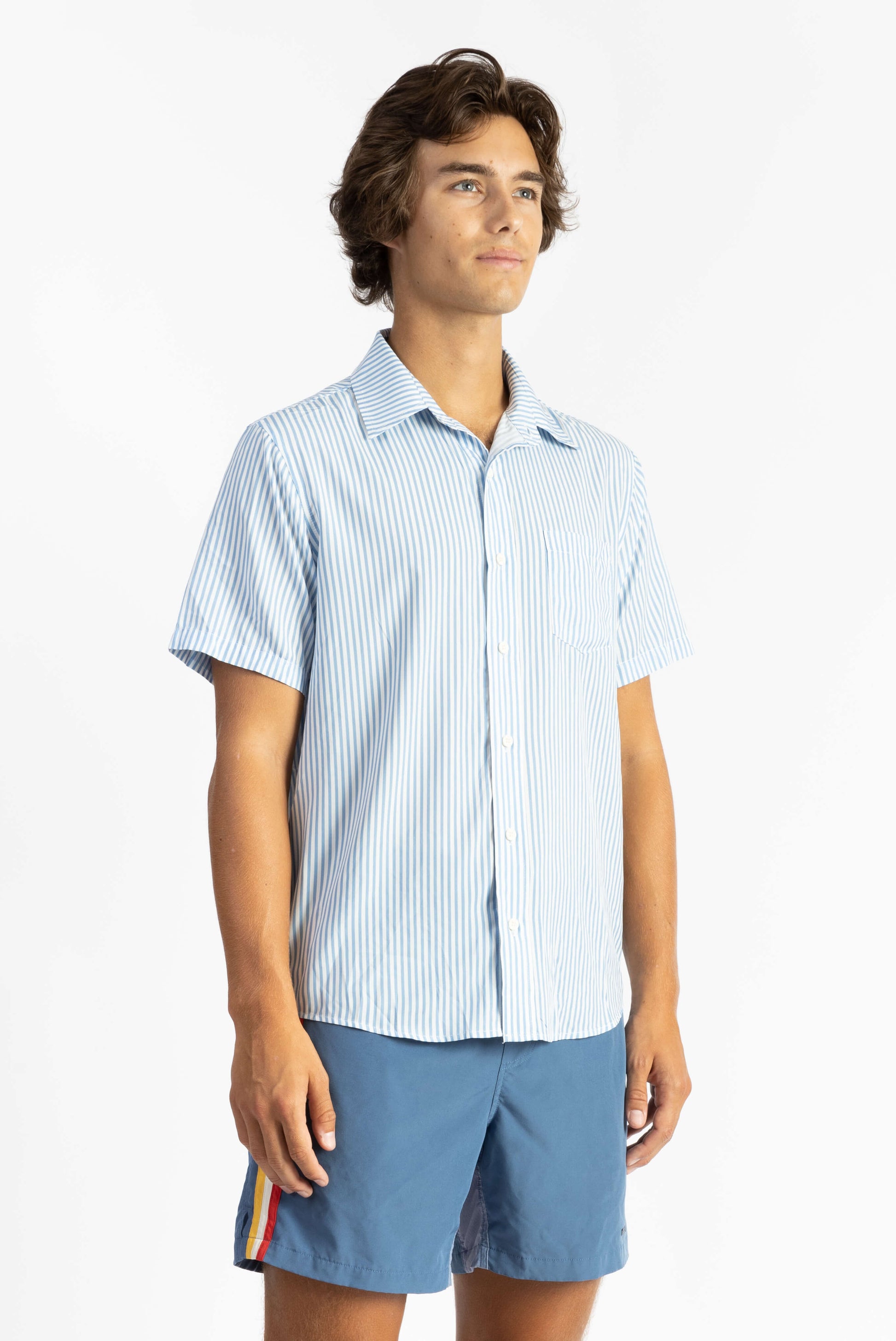 a man wearing a formal light weight Blue Striped Breeze Button Up shirt with blue shorts