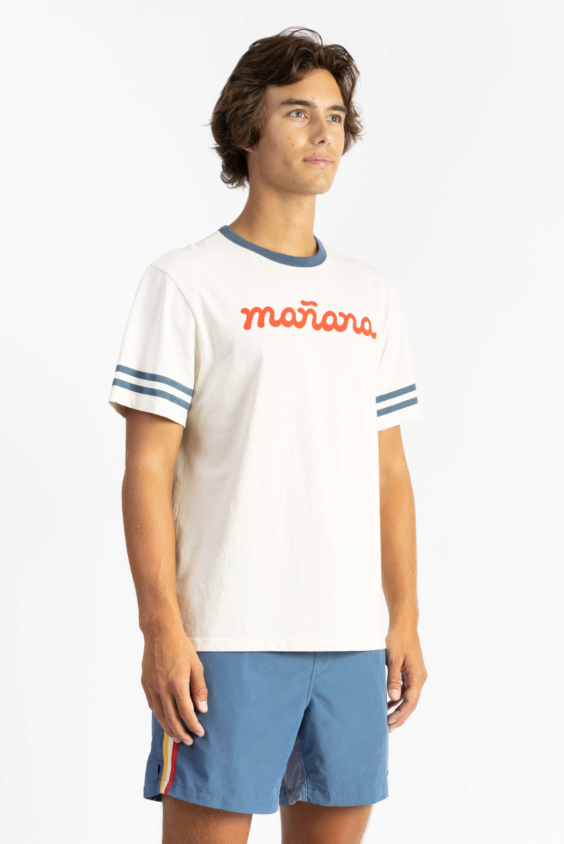 A man wearing Off White tee shirt having Manana branding with blue shorts