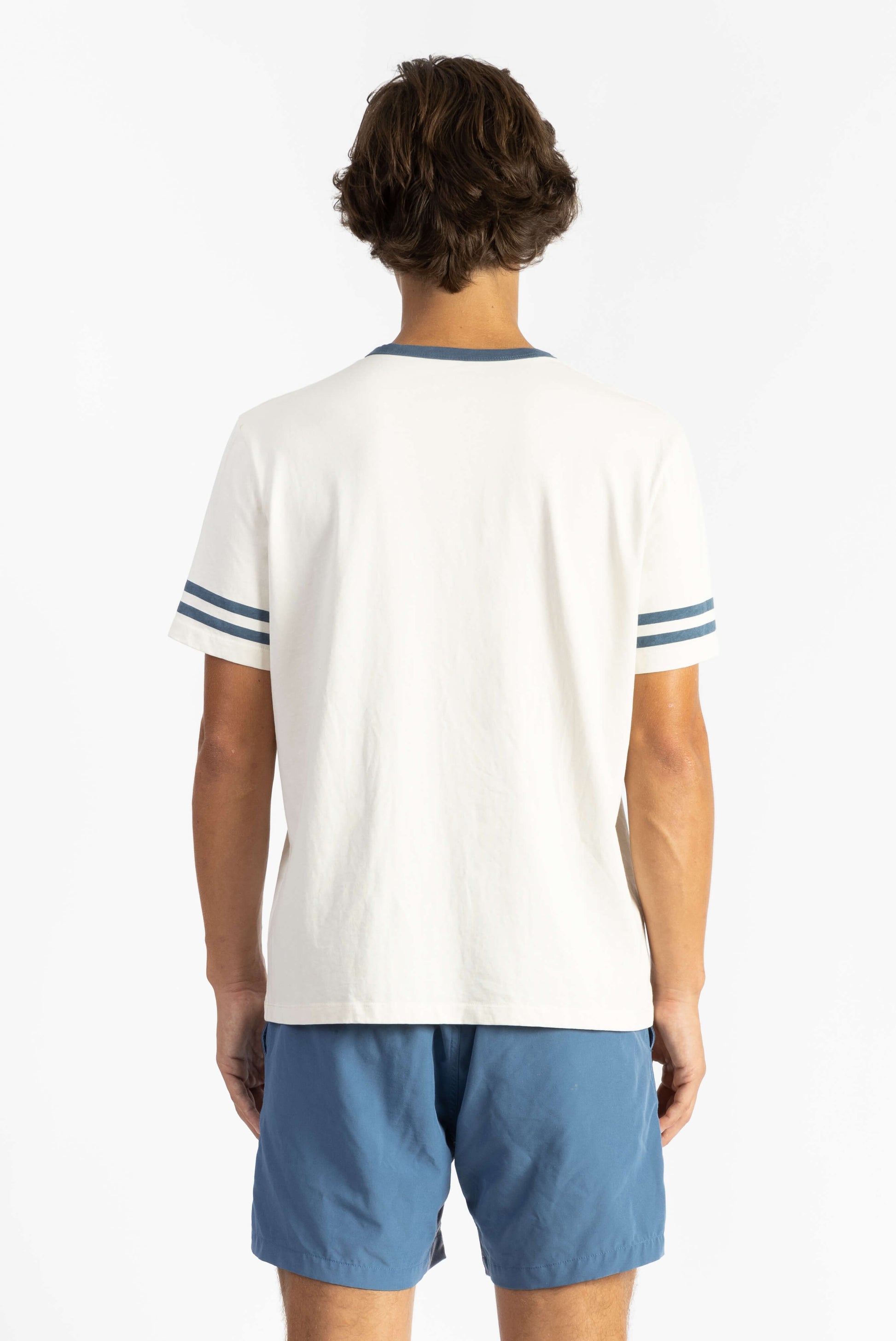 A man wearing Off White tee shirt having Manana branding with blue shorts