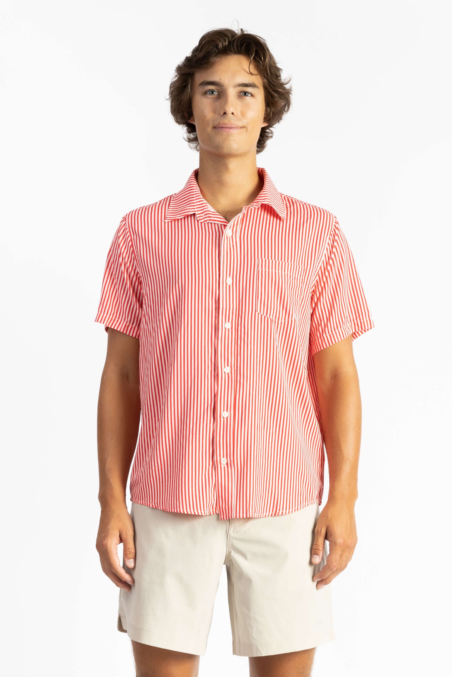 A man wearing a Red Stripes Breeze Button Up Shirt with white shorts