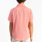 A man wearing a Red Stripes Breeze Button Up Shirt with white shorts