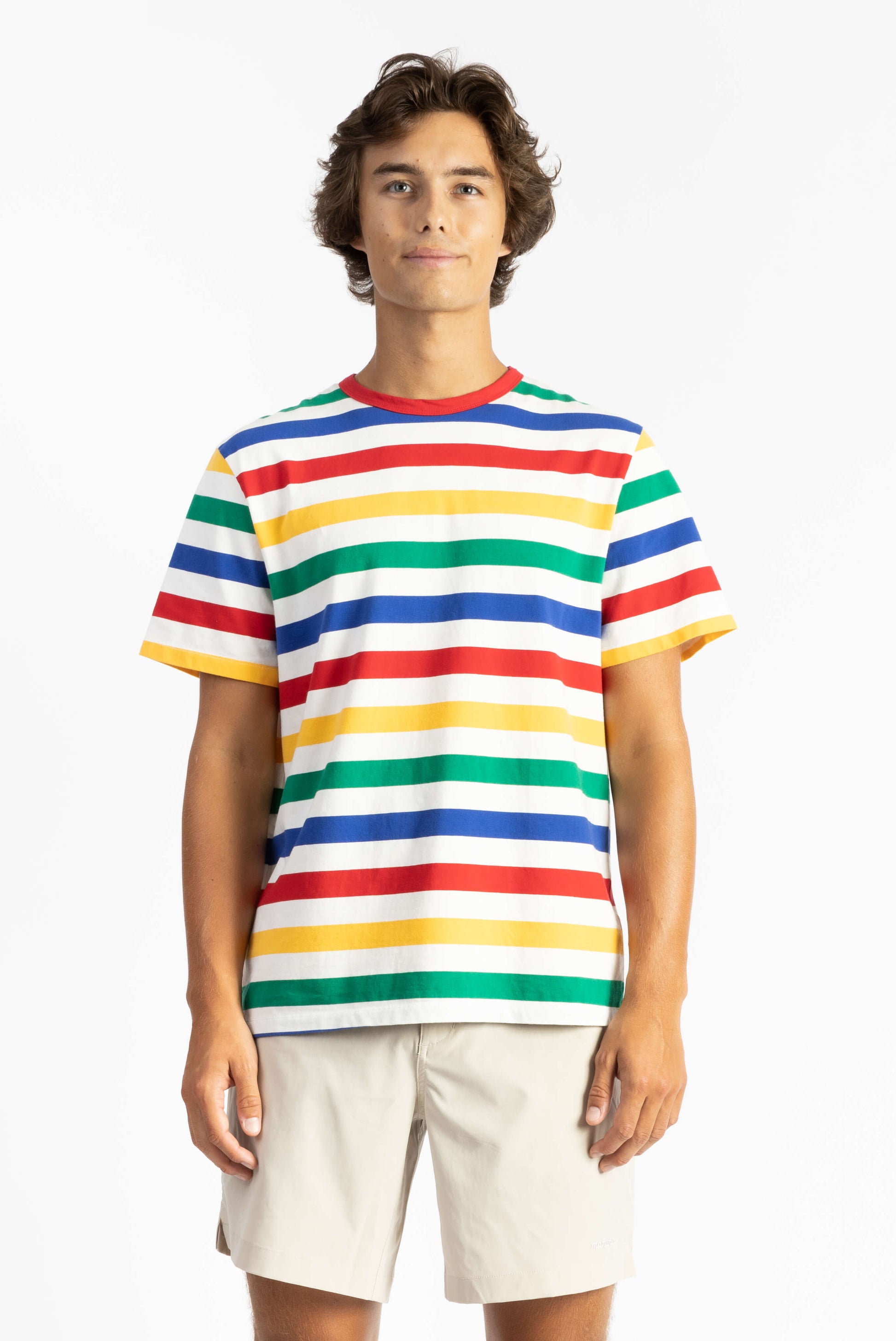 a man wearing a multi color tee shirt with big stripes and yellow shorts