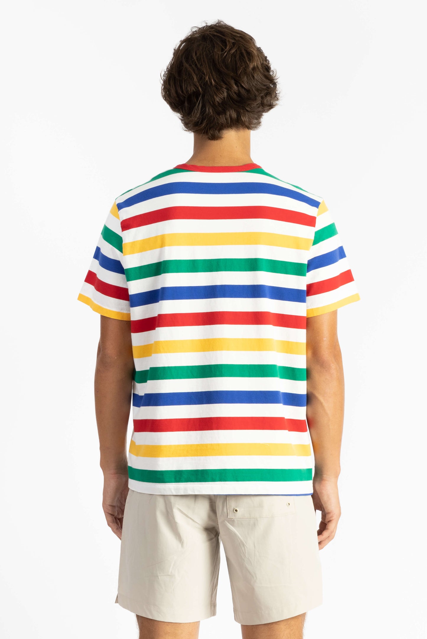a man wearing a multi color tee shirt with big stripes and yellow shorts
