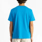 picture of a man wearing an ocean blue tee shirt with manana branding and white shorts