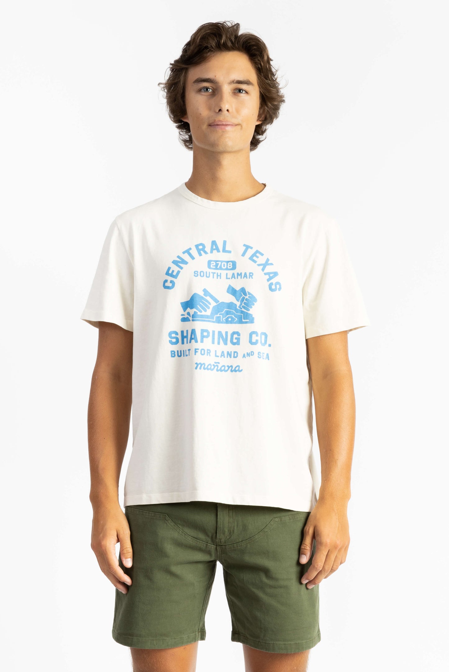 A man wearing a Off White Workshop Tee Shirt having Manana branding with green shorts
