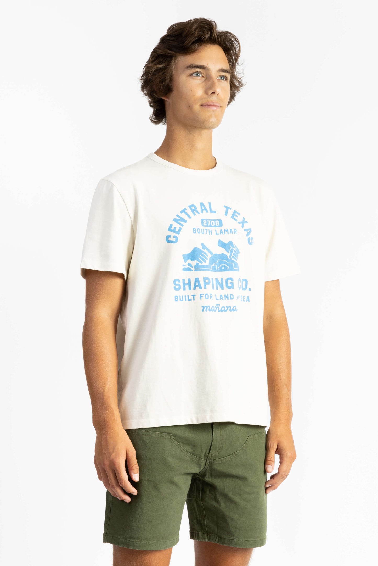 A man wearing a Off White Workshop Tee Shirt having Manana branding with green shorts