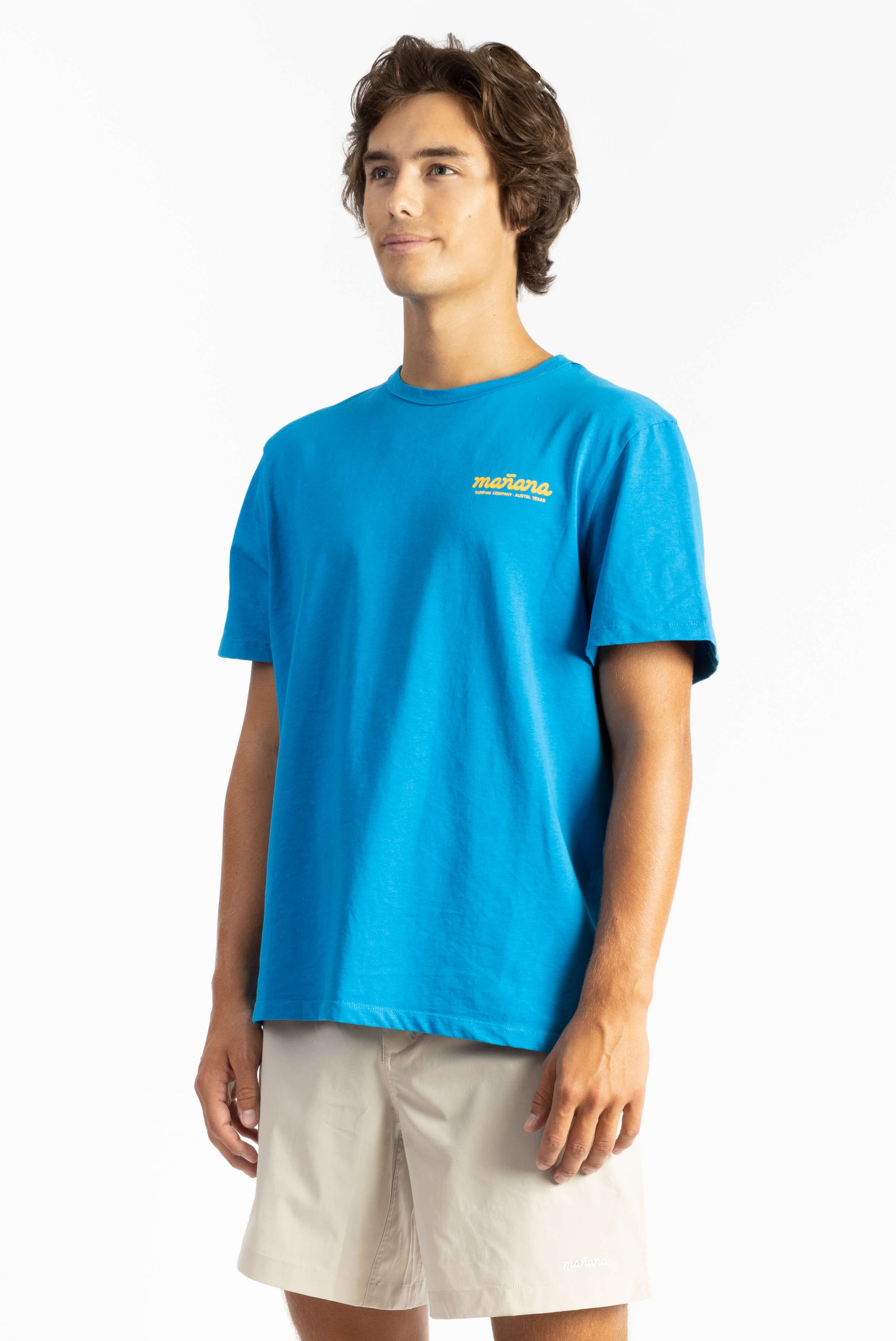 picture of a man wearing an ocean blue tee shirt with manana branding and white shorts