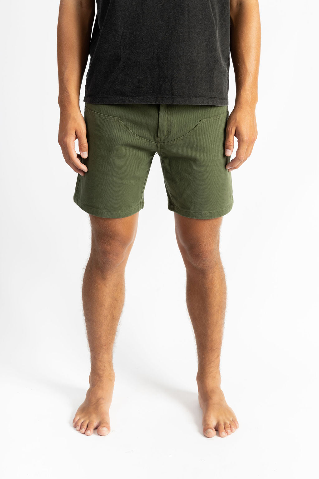 A man wearing an Olive color work shorts with a black shirt