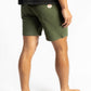 A man wearing an Olive color work shorts having Manana branding with a black shirt