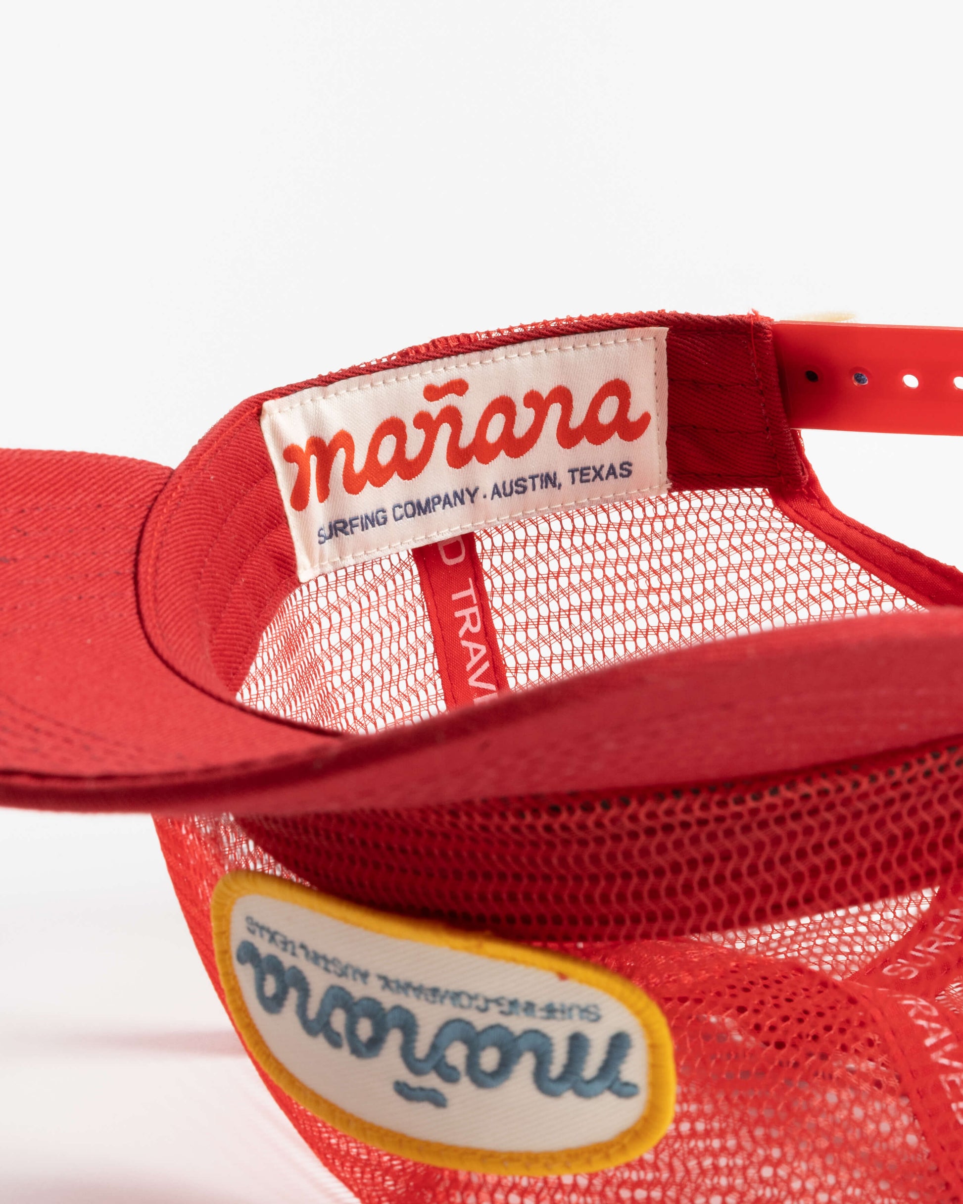 a picture of red mesh hat with Manana written on it