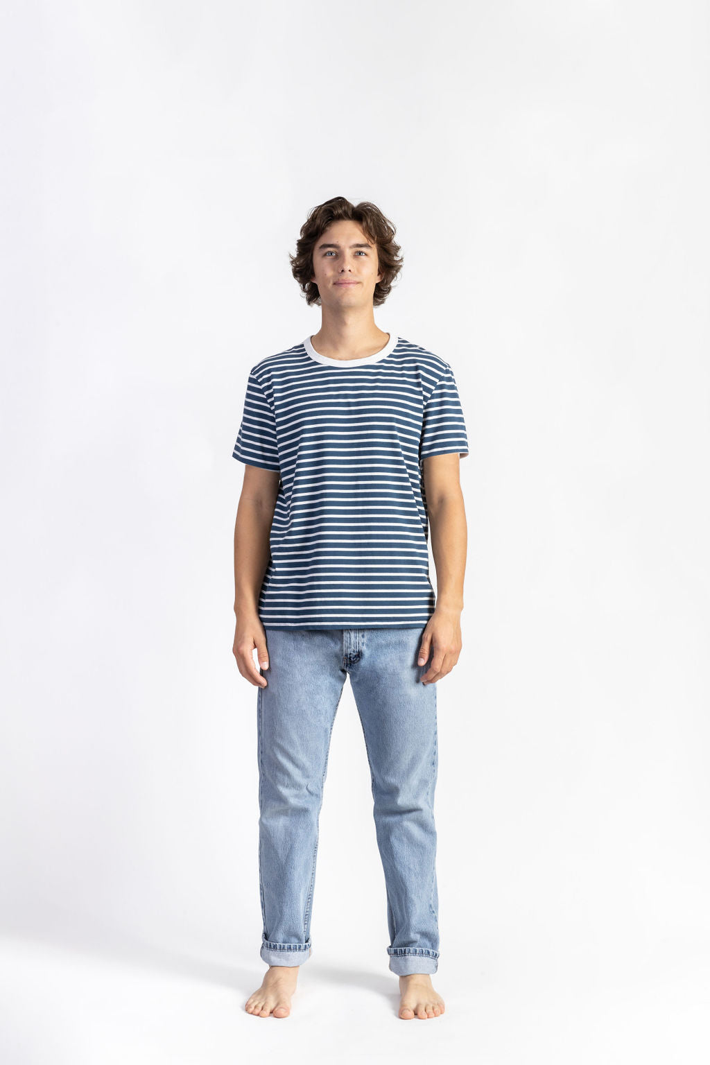 A man wearing a Blue/White Striped Tee Shirt with light blue jeans