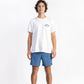 A man wearing a White Shop Tee having Manana branding with blue shorts